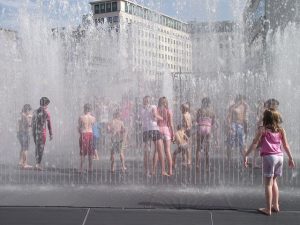 Picture showing children playing in street fountains